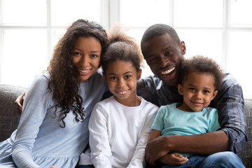 Happy black family of four dad mom and little son daughter, loving african mother father embrace 2...