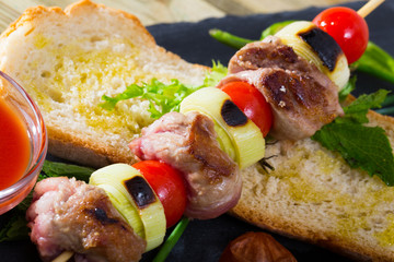 Baked shashlik of lamb with onion and tomatoes served  with ketchup and bread