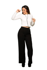 Full body of Pretty woman with glasses listening to music with headphones and dancing