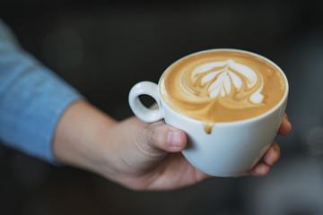 Latte art coffee in hands