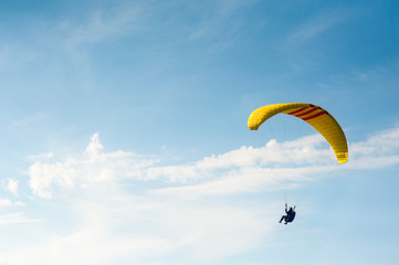 Alone paraglider flying in the blue sky against the background of clouds. Paragliding in the sky on...