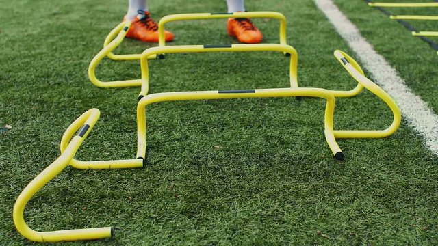 Soccer agility training equipment. Professional football player with training hurdles. 4k slow motion