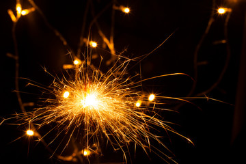 festive background with sparkler and new year lights closeup