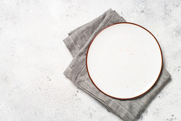 White craft plate and napkin on white stone table. 