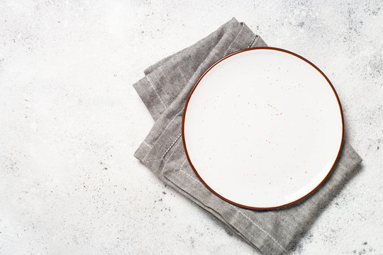 White Craft Plate And Napkin On White Stone Table. 