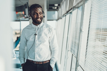 Young smiling operator man working via headset