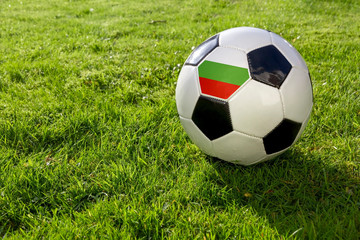 Fototapeta premium Football on a grass pitch with Bulgaria Flag