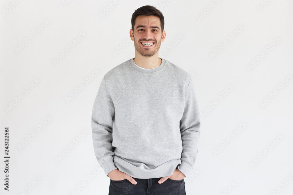 Sticker Daylight portrait of young laughing handsome man, wearing oversized sweatshirt, isolated on gray background