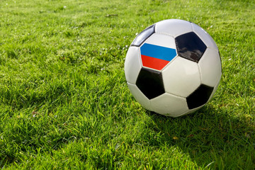 Football on a grass pitch with Russia Flag