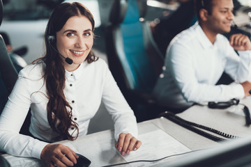 Smiling female operator sitting on dispatch board