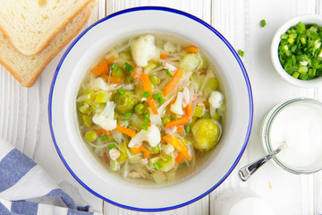 Vegetable soup with cauliflower, Brussels sprouts, white cabbage, carrots and green peas. Delicious healthy lunch, spring food