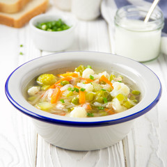 Vegetable soup with cauliflower, Brussels sprouts, white cabbage, carrots and green peas. Delicious healthy lunch, spring food