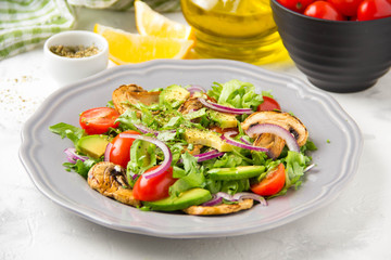 Fresh spring salad with mushrooms, cherry tomatoes, avocado and onions. Tasty vegetarian lunch, healthy food