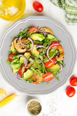 Fresh spring salad with mushrooms, cherry tomatoes, avocado and onions. Tasty vegetarian lunch, healthy food