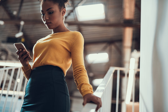 Attractive Afro American Lady In Yellow Sweater Using Cellphone