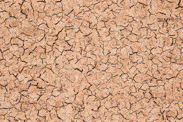 Dry cracked earth, The desert background. The global shortage of water on the planet. Deep cracks in the brown land as a symbol of hot climate and drought.