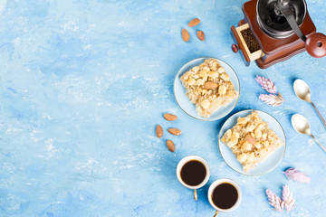 Two coffee cups, coffee grinder and apple pie on blue artistic background.