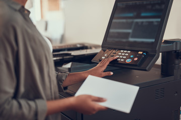 Young afro american lady using office equipment