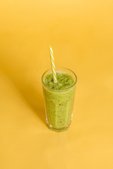 fresh green juice with kiwi on yellow background.fruit and vegetable juice.