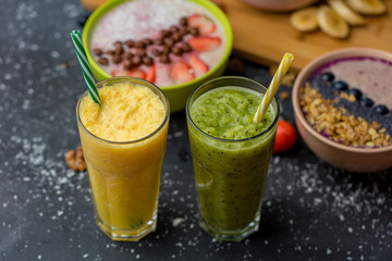 Freshly blended fruit smoothies in glasses. Yellow, green drinks. close up photo
