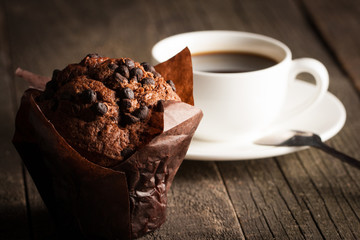 chocolate dark cooked muffin with mint on a wooden table with cinnamon, anise, chocolate.