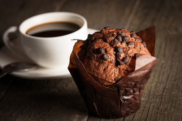 chocolate dark cooked muffin with mint on a wooden table with cinnamon, anise, chocolate.