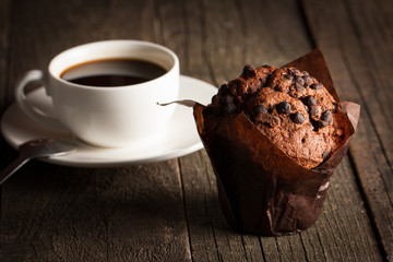 chocolate dark cooked muffin with mint on a wooden table with cinnamon, anise, chocolate.