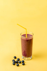 begin the day with a glass of purple smoothie and have good mood all day. delicious drink for child. isolated yellow background