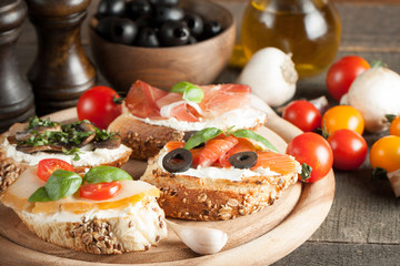 Italian tomato and cheese bruschetta. Tapas, antipasti with chopped vegetables, herbs and oil on grilled ciabatta and baguette bread.