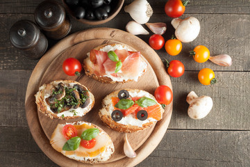 Italian tomato and cheese bruschetta. Tapas, antipasti with chopped vegetables, herbs and oil on grilled ciabatta and baguette bread.
