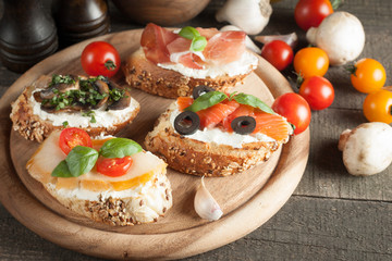Italian tomato and cheese bruschetta. Tapas, antipasti with chopped vegetables, herbs and oil on grilled ciabatta and baguette bread.