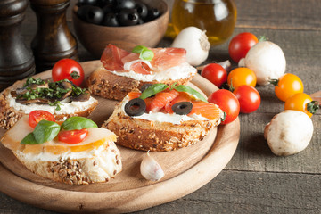 Italian tomato and cheese bruschetta. Tapas, antipasti with chopped vegetables, herbs and oil on grilled ciabatta and baguette bread.