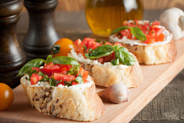 Italian tomato and cheese bruschetta. Tapas, antipasti with chopped vegetables, herbs and oil on grilled ciabatta and baguette bread.