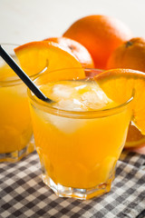 Photo of fresh orange juice in the glass jar. Summer healthy organic drink concept. Cold beverages with ice and orange fruits.