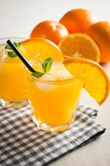 Photo of fresh orange juice in the glass jar. Summer healthy organic drink concept. Cold beverages with ice and orange fruits.
