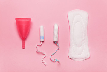 coral Pad, menstrual cup, tampon on a pink background.