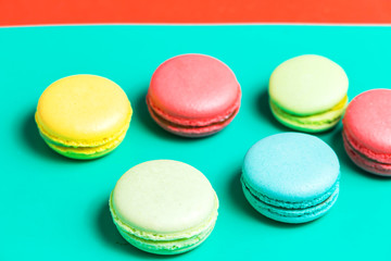 Fototapeta na wymiar Closeup of different macaroons on a colorful turquoise background
