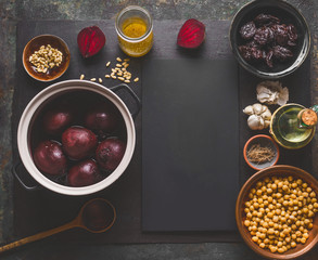 Beet root salad preparation with pine nuts, chickpeas and prunes on dark background, top view with copy space for your design. Healthy clean, low calories food and diet and detox eating concept