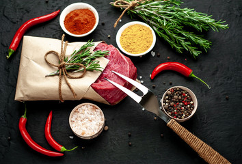 meat from a butcher shop, wrapped in paper. A piece of beef on a concrete black background