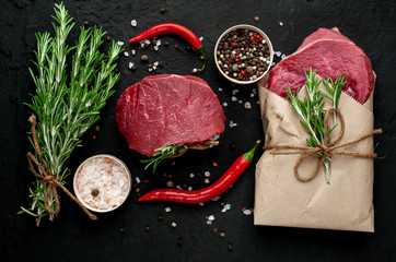 meat from a butcher shop, steak with ingredients. A piece of beef on a concrete black background