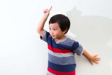 Portrait of Cute little boy pointing up on white background