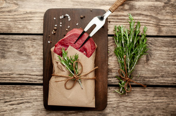 meat from a butcher shop, wrapped in paper. A piece of beef on a wooden background