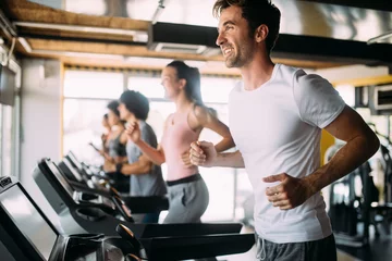 Foto auf Acrylglas Fitness Gruppe sportlicher Menschen in einem Fitnessstudio. Konzepte zu Lifestyle und Sport im Fitnessclub