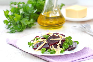Salad with beet, cheese and greens served witn oil and balsamic vinegar