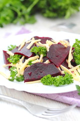 Salad with beet, cheese and greens served witn oil and balsamic vinegar