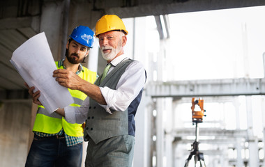Engineer, foreman and worker discussing in building construction site