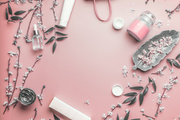 Cosmetic concept. Facial skin care products and paper shopping bag on pastel pink background with...