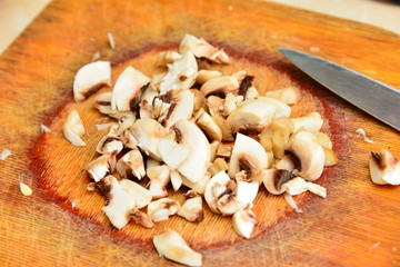 White mushroom is cut with a knife on a cutting board, concept of healthy nutrition.