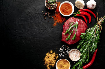 meat from a butcher shop, steak with ingredients. A piece of beef on a concrete black background