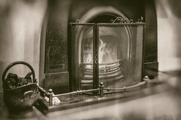 Vintage fireplace with marble surroundings fireside iron black bucket with coal in retro sepia style